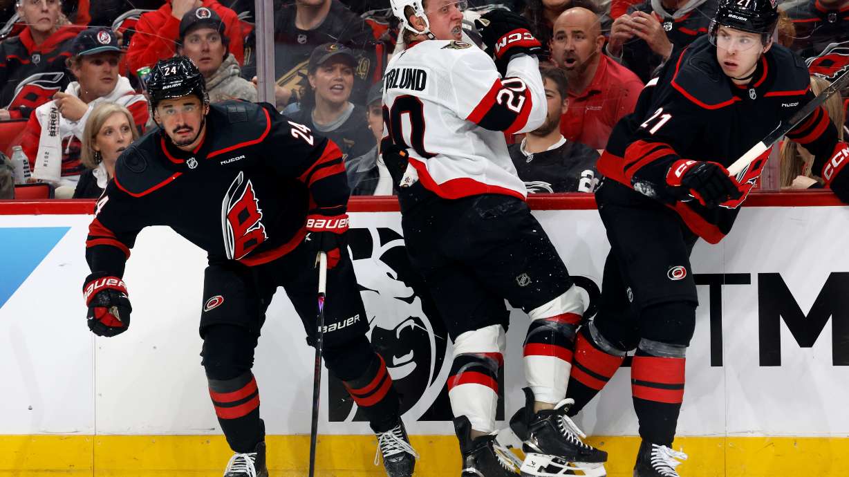 Ottawa Senators' Fabian Zetterlund (20) collides with Carolina Hurricanes' Seth Jarvis (24) and Alexander Nikishin (21) the first period of Game 2 of an NHL hockey Stanley Cup first-round playoff series in Raleigh, N.C., Monday, April 20, 2026.