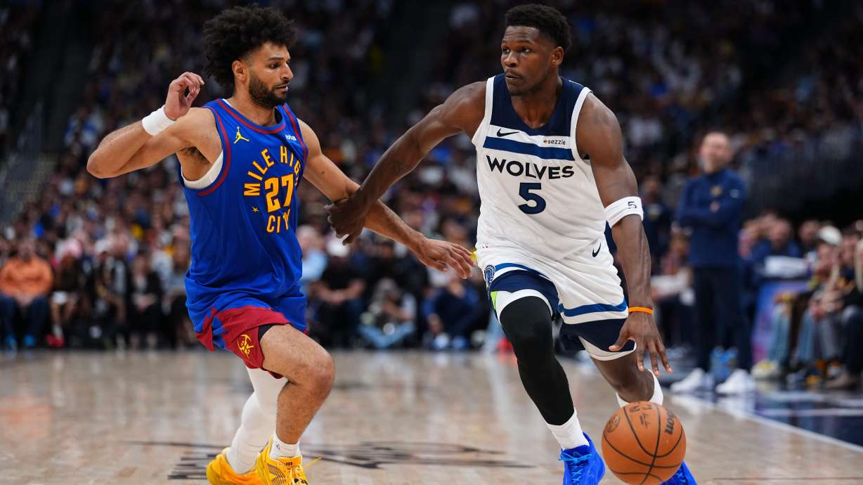 Minnesota Timberwolves guard Anthony Edwards (5) drives to the basket against Denver Nuggets guard Jamal Murray (27) during the second half in Game 2 of a first-round NBA playoffs basketball series Monday, April 20, 2026, in Denver.