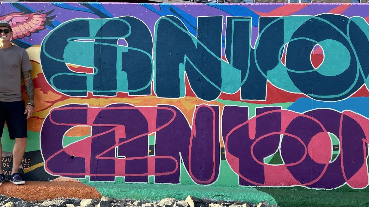 Jared Jones stands in front of his mural along the Mayor's Loop Trail in St. George, one of 20 unveiled Monday.