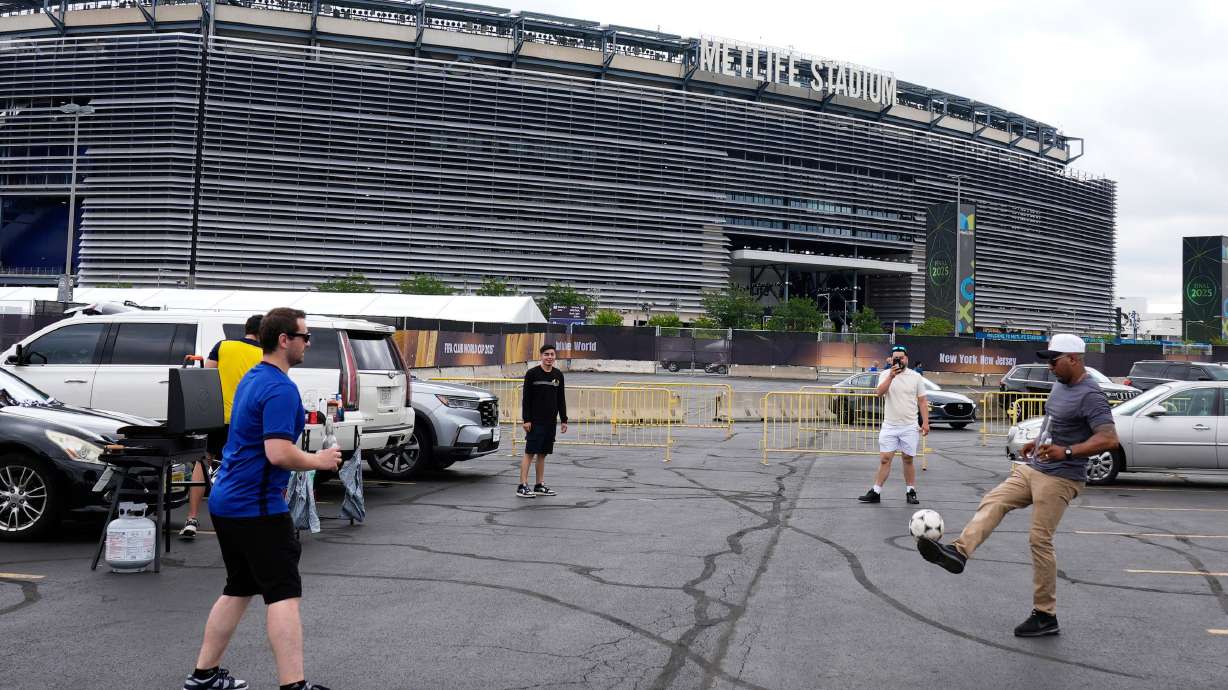 FILE - Fans play with a ball outside the Metlife Stadium prior to the Club World Cup final soccer match between Chelsea and PSG in East Rutherford, N.J., Sunday, July 13, 2025.