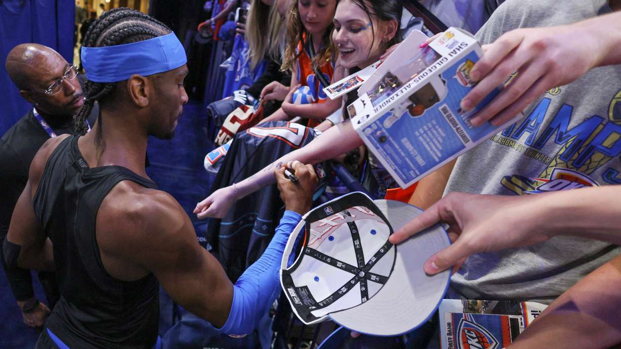 Oklahoma City Thunder guard Shai Gilgeous-Alexander, bottom left, gives autographs to fans before Game 1 of a first-round NBA playoffs basketball series against the Phoenix Suns, Sunday, April 19, 2026, in Oklahoma City.