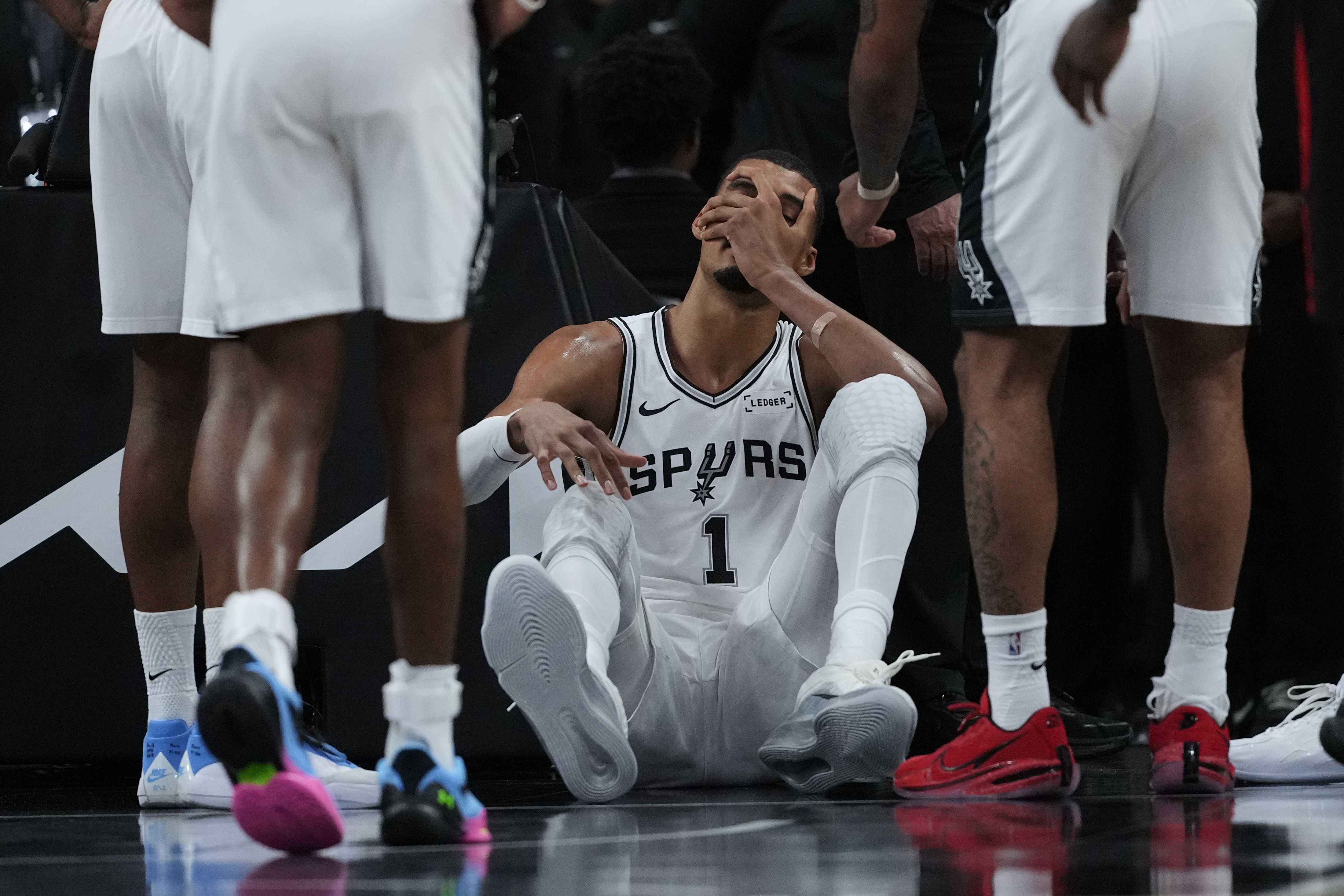 San Antonio Spurs forward Victor Wembanyama (1) sits on the court after a hard fall during the first half in Game 2 of a first-round NBA playoffs basketball series against the Portland Trail Blazers in San Antonio, Tuesday, April 21, 2026. 