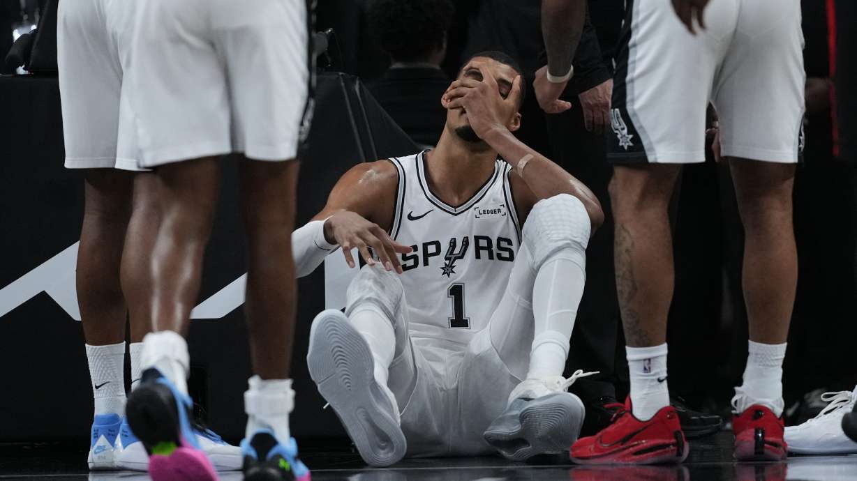 San Antonio Spurs forward Victor Wembanyama (1) sits on the court after a hard fall during the first half in Game 2 of a first-round NBA playoffs basketball series against the Portland Trail Blazers in San Antonio, Tuesday, April 21, 2026.