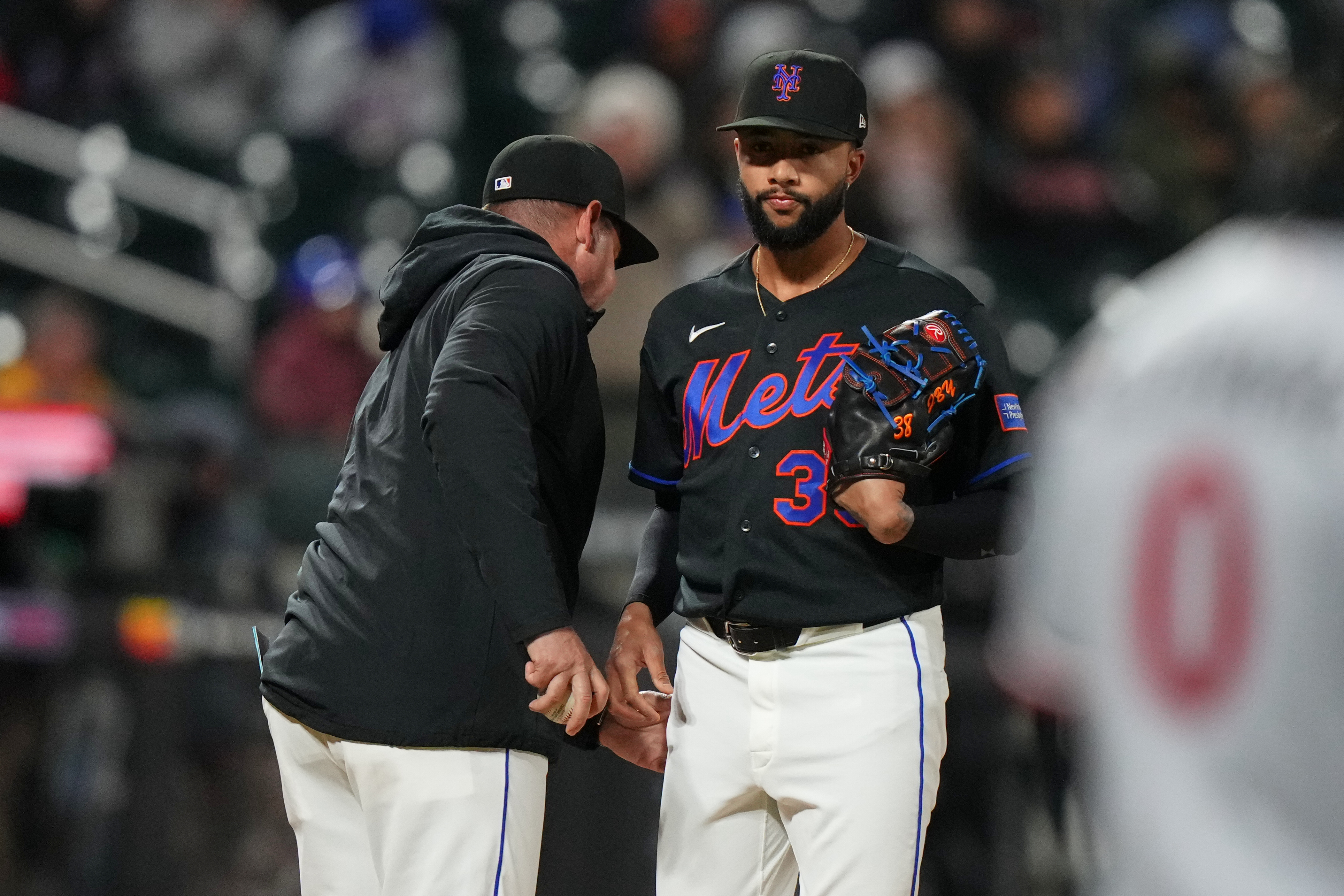 New York Mets pitcher Devin Williams, right, hands the ball to manager Carlos Mendoza as he leaves during the ninth inning of a baseball game against the Minnesota Twins Tuesday, April 21, 2026, in New York. 