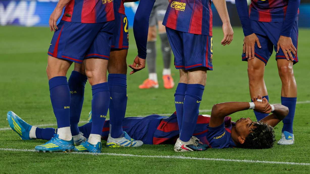 Barcelona's Lamine Yamal lies on the pitch in pain during the Spanish La Liga soccer match between Barcelona and Celta Vigo in Barcelona, Spain, Wednesday, April 22, 2026.