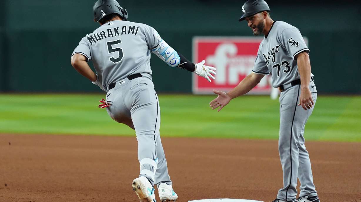Chicago White Sox's Munetaka Murakami (5), of Japan, celebrates his two-run home run against the Arizona Diamondbacks with White Sox third base coach Jose Leger (73) during the seventh inning of a baseball game, Wednesday, April 22, 2026, in Phoenix.