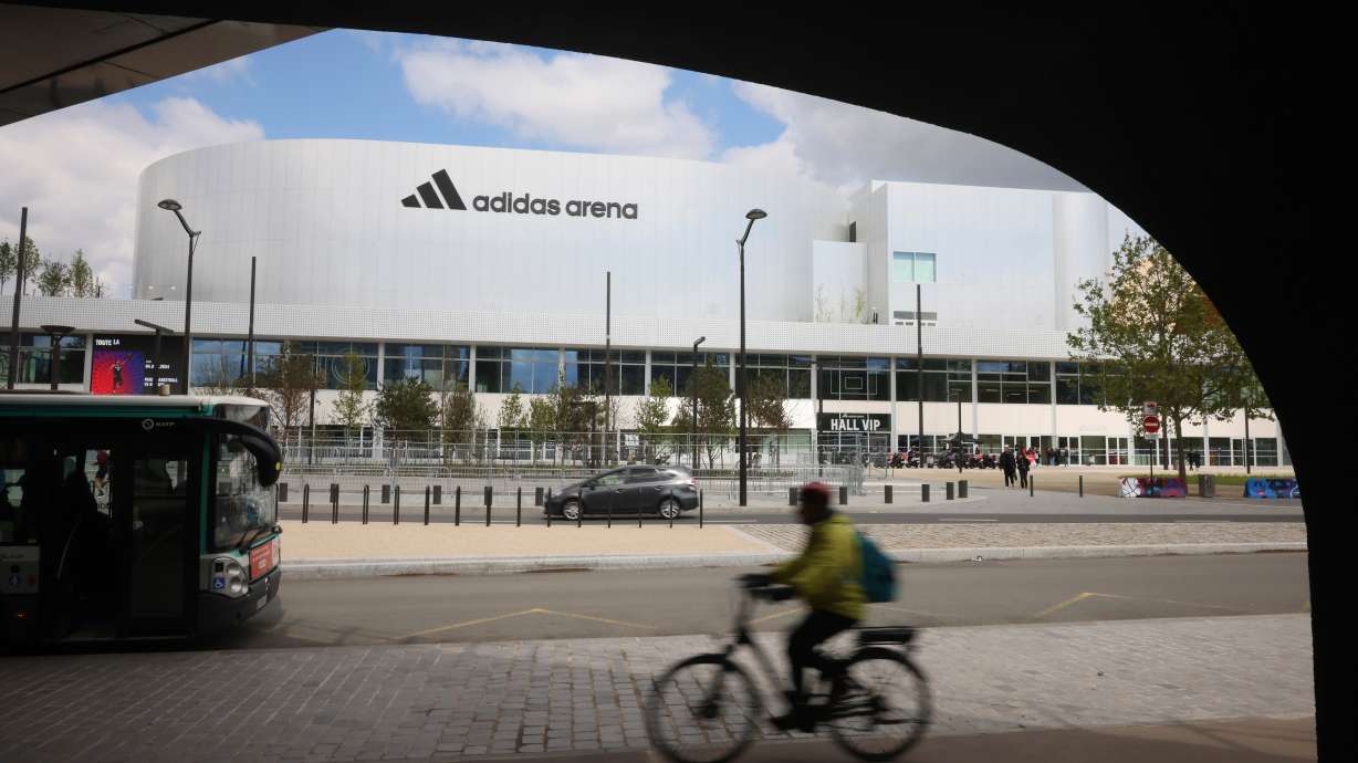 FILE - A cyclist rides past the Adidas Arena, April 18, 2024, in Paris, France.