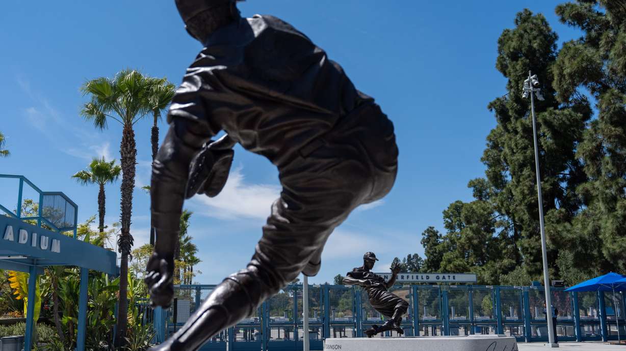 Statues of Sandy Koufax, foreground, and Jackie Robinson stand outside Dodger Stadium before a baseball game between the Los Angeles Dodgers and the New York Mets, Wednesday, April 15, 2026, in Los Angeles.
