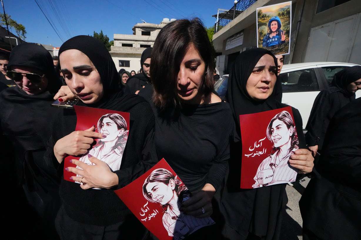 Mourners hold posters with portraits of Lebanese journalist Amal Khalil, who was killed Wednesday in an Israeli airstrike, during her funeral procession in the village of Baysariyeh in southern Lebanon on Thursday. Both Israel and Lebanon have accused the other of breaking the truce, which was extended by President Donald Trump.