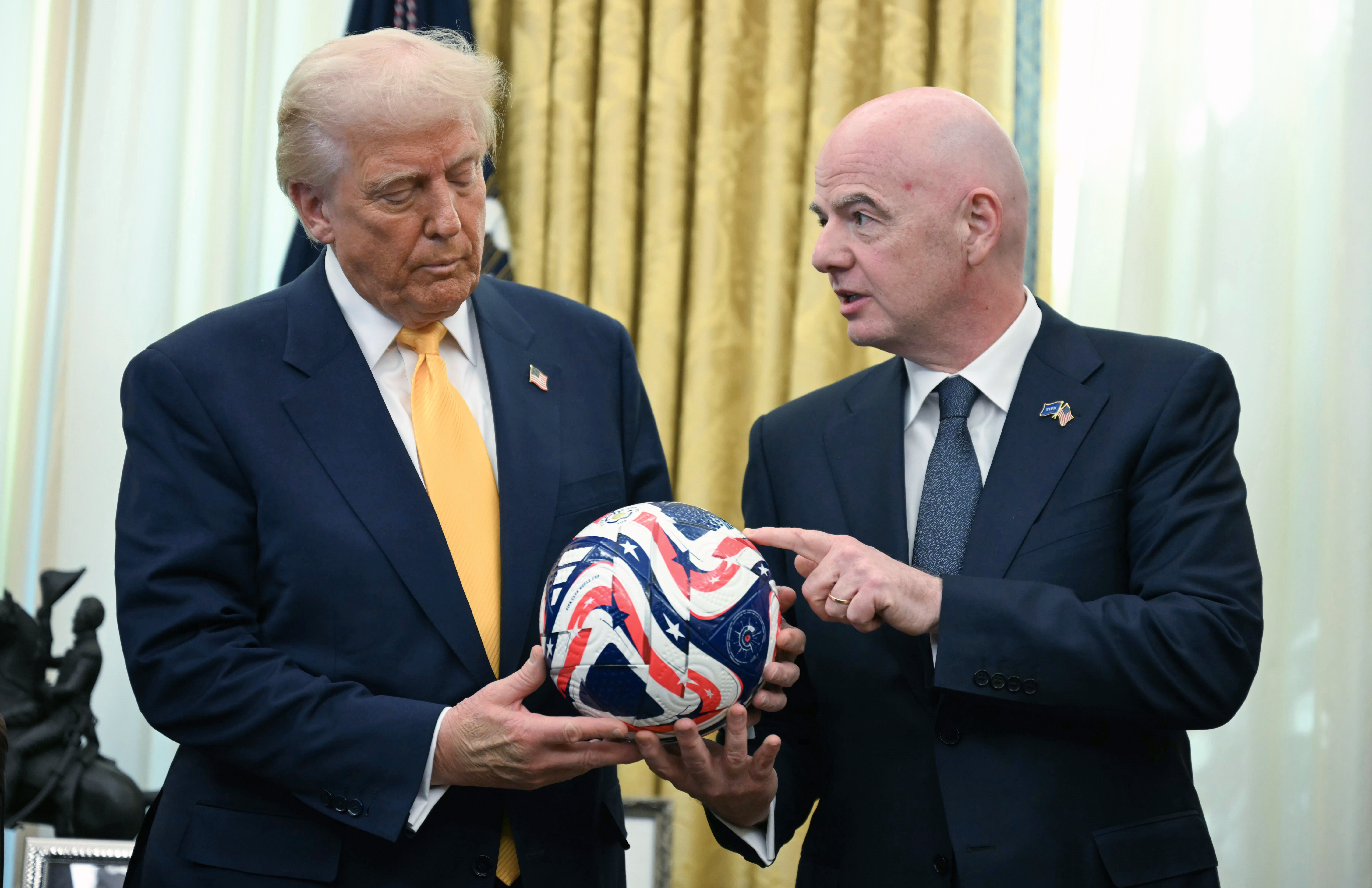 FILE - FIFA President Gianni Infantino, right, presents President Donald Trump with the new FIFA Club World Cup official ball in the Oval Office of the White House in Washington, March 7, 2025. 