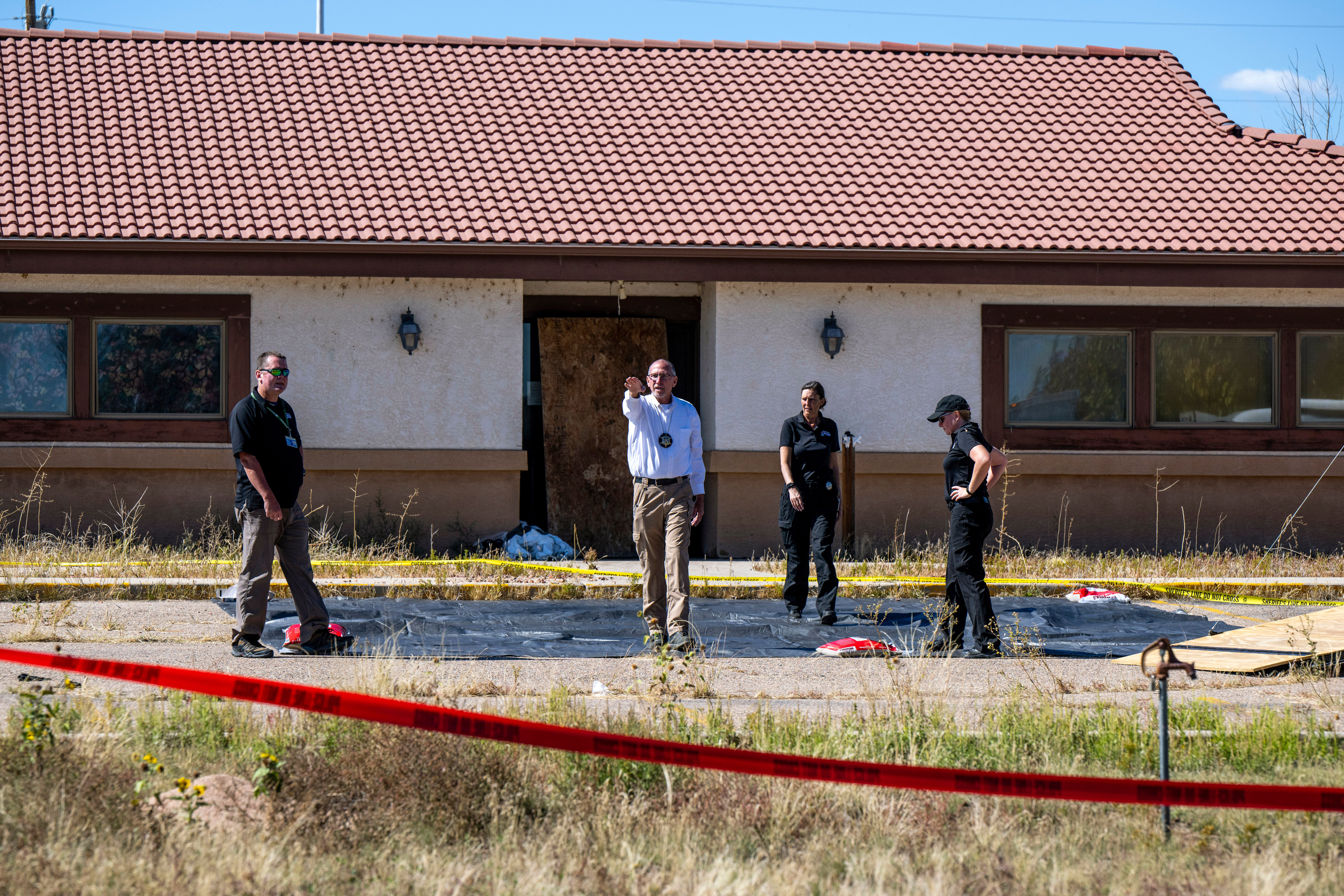 Fremont County coroner Randy Keller and other authorities survey the area at the Return to Nature Funeral Home, Oct. 7, 2023, in Penrose, Colo. The former owner of the funeral home was sentenced to 30 years in prison on Friday.