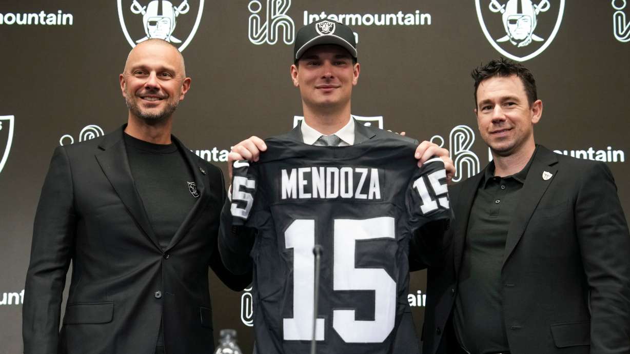 From left to right, Las Vegas Raiders general manager John Spytek, first-round draft pick Fernando Mendoza and head coach Klint Kubiak pose for a photo during an NFL football news conference Friday, April 24, 2026, in Henderson, Nev.