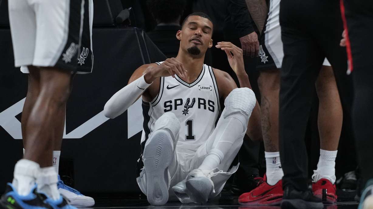 San Antonio Spurs forward Victor Wembanyama (1) sits on the court after a hard fall during the first half in Game 2 of a first-round NBA playoffs basketball series against the Portland Trail Blazers in San Antonio, Tuesday, April 21, 2026.