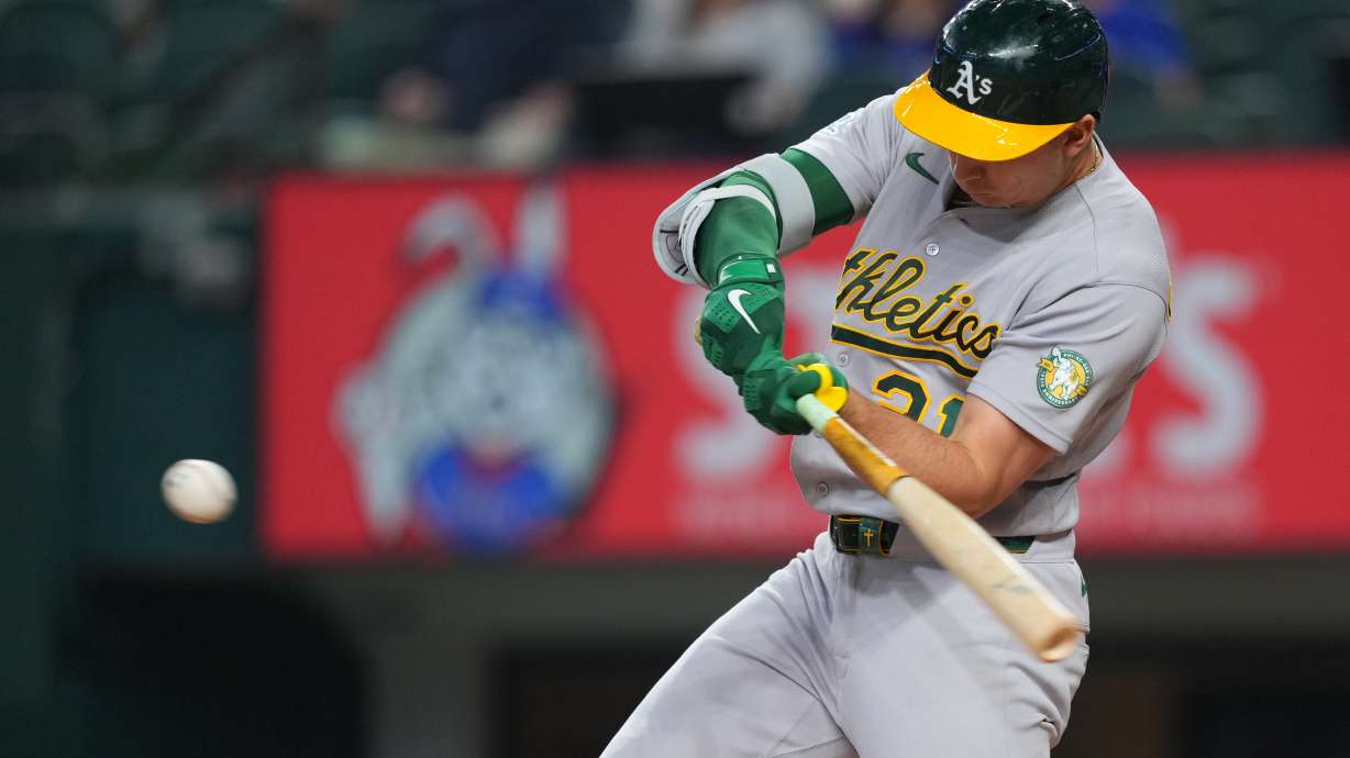 Athletics' Tyler Soderstrom swings at a pitch from Texas Rangers starting pitcher Nathan Eovaldi while connecting on a solo home run during the first inning of a baseball game Friday, April 24, 2026, in Arlington, Texas.