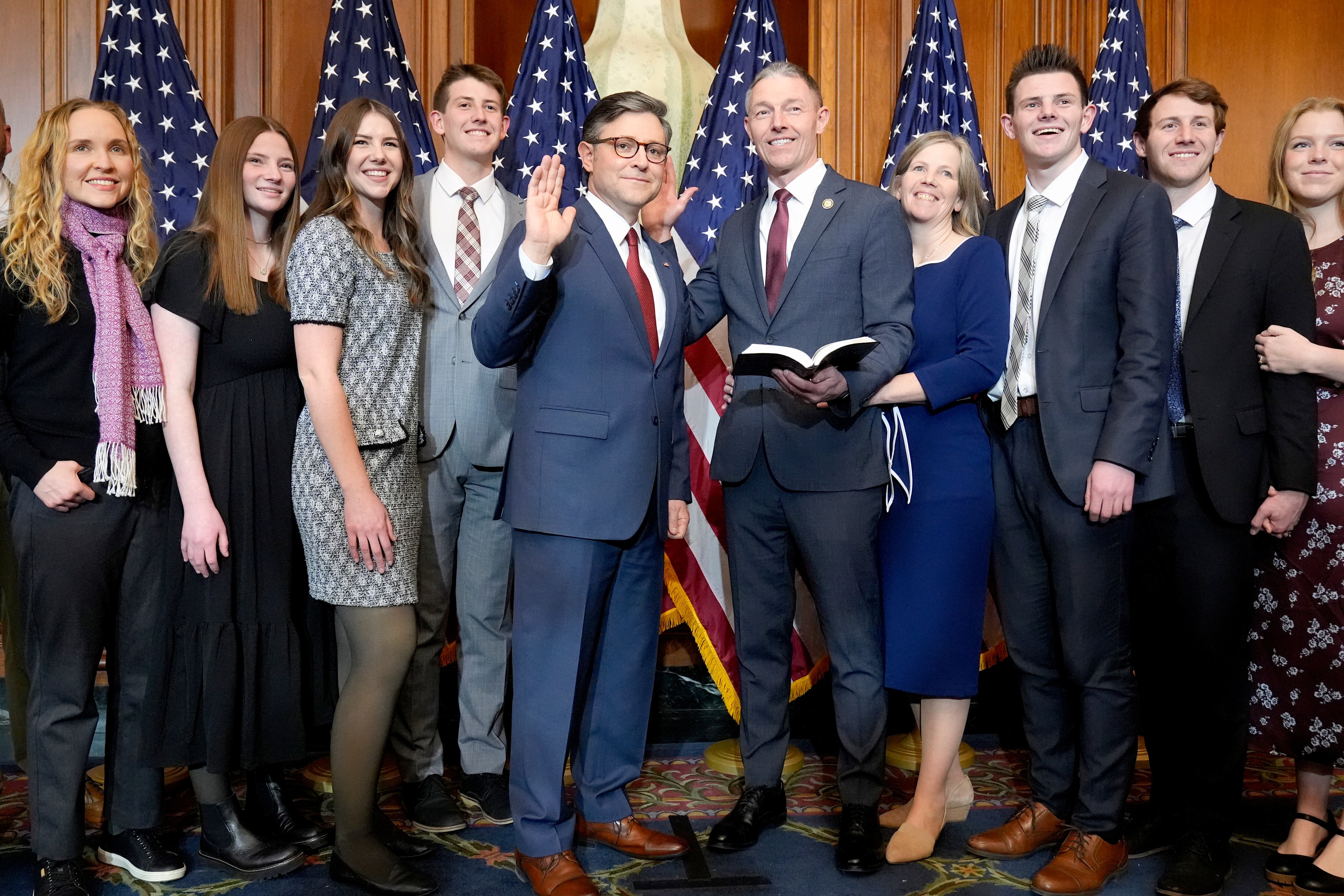 House Speaker Mike Johnson, R-La., center left, poses during a ceremonial swearing-in with Rep.-elect Mike Kennedy, R-Utah, center right, and members of Kennedy's family, in the Rayburn Room at the Capitol in Washington, Jan. 3, 2025.