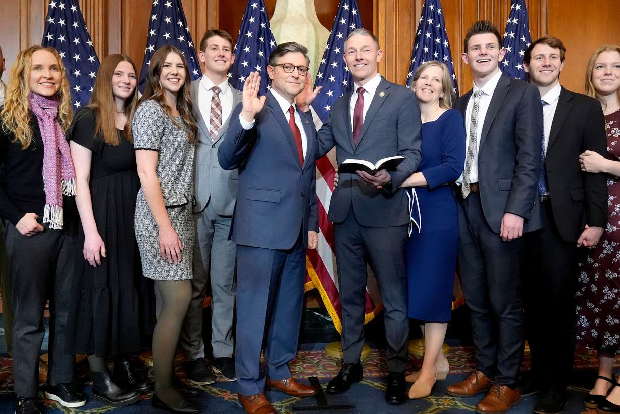 House Speaker Mike Johnson, R-La., center left, poses during a ceremonial swearing-in with Rep.-elect Mike Kennedy, R-Utah, center right, and members of Kennedy's family, in the Rayburn Room at the Capitol in Washington, Jan. 3, 2025.