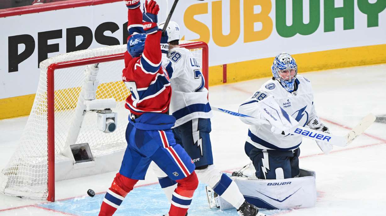 Montreal Canadiens' Kirby Dach (77) reacts to a goal by teammate Lane Hutson against Tampa Bay Lightning goaltender Andrei Vasilevskiy (88) during overtime in an NHL hockey playoff game in Montreal, Friday, April 24, 2026.