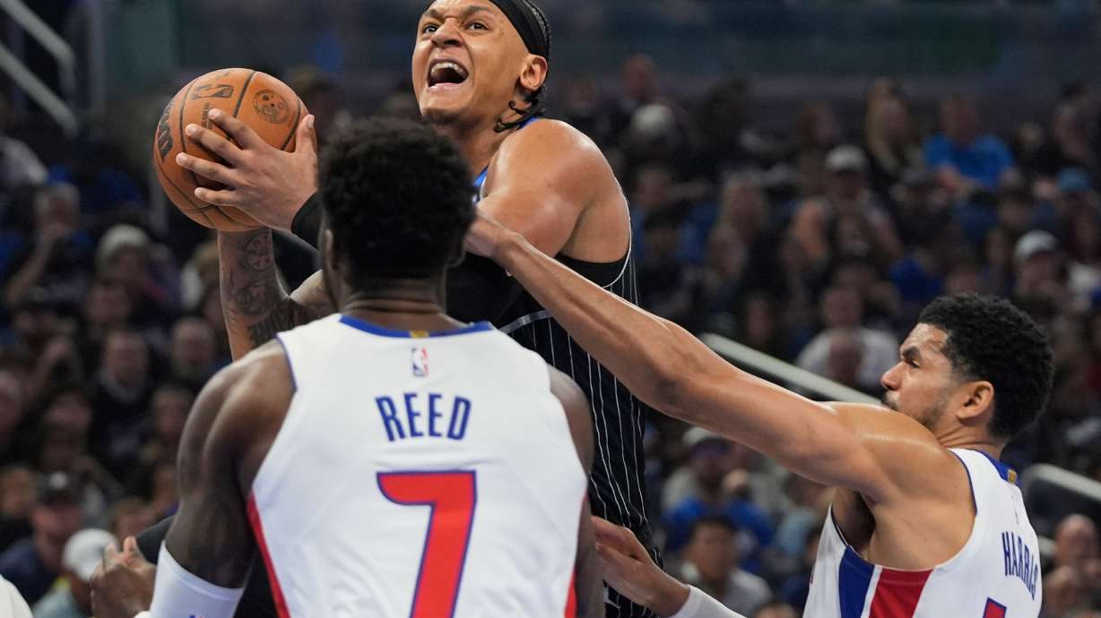 Orlando Magic forward Paolo Banchero, center, goes up for a shot over Detroit Pistons forward Paul Reed (7) and forward Tobias Harris, right, during the second half in Game 3 of a first-round NBA basketball playoff series, Saturday, April 25, 2026, in Orlando, Fla.