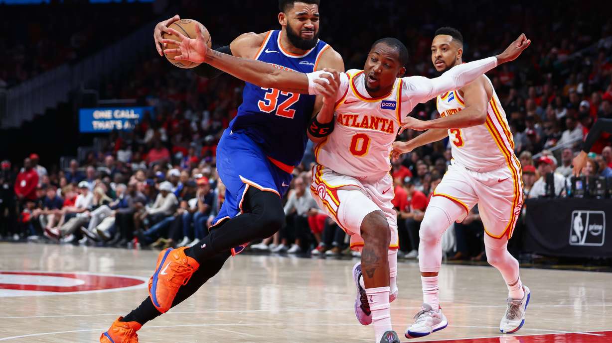 New York Knicks center Karl-Anthony Towns (32) drives to the basket against Atlanta Hawks forward Jonathan Kuminga (0) during the second half in Game 3 of a first-round NBA playoffs basketball series, Thursday, April 23, 2026, in Atlanta.