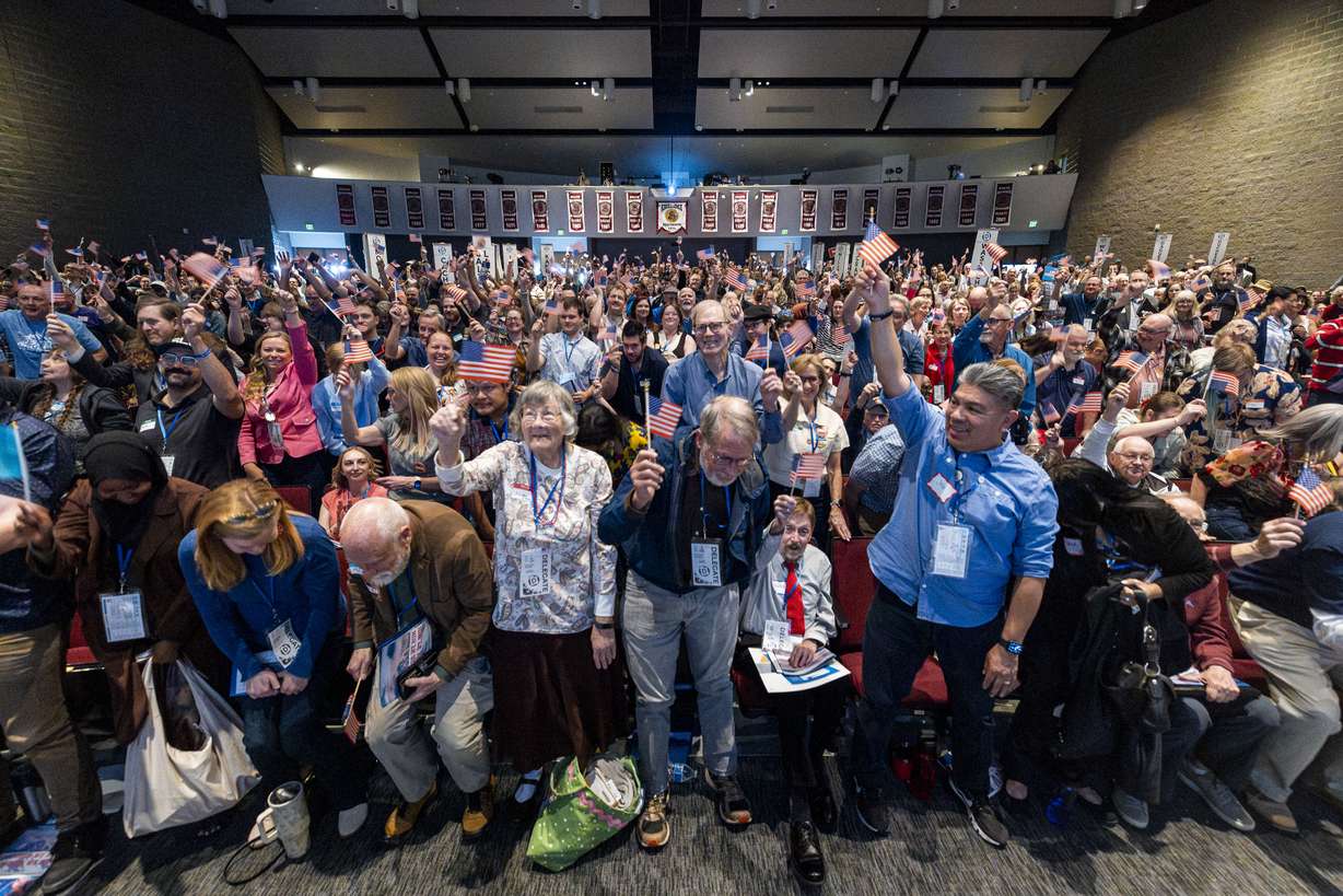 Attendees wave American flags as they create a wave throughout the crowd during the Utah Democratic Party State Convention held at Jordan High School in Sandy on Saturday.