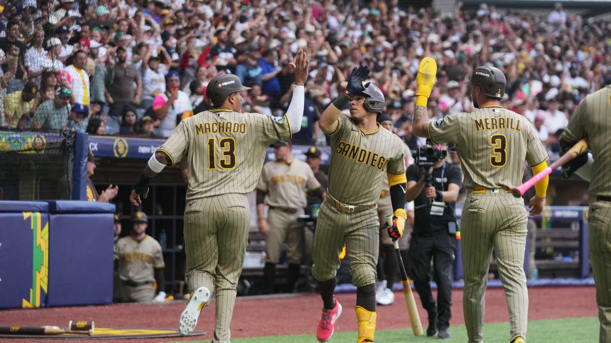 San Diego Padres' Manny Machado, left, is congratulated after scoring against the Arizona Diamondbacks during the seventh inning of a baseball game in Mexico City, Saturday, April 25, 2026.