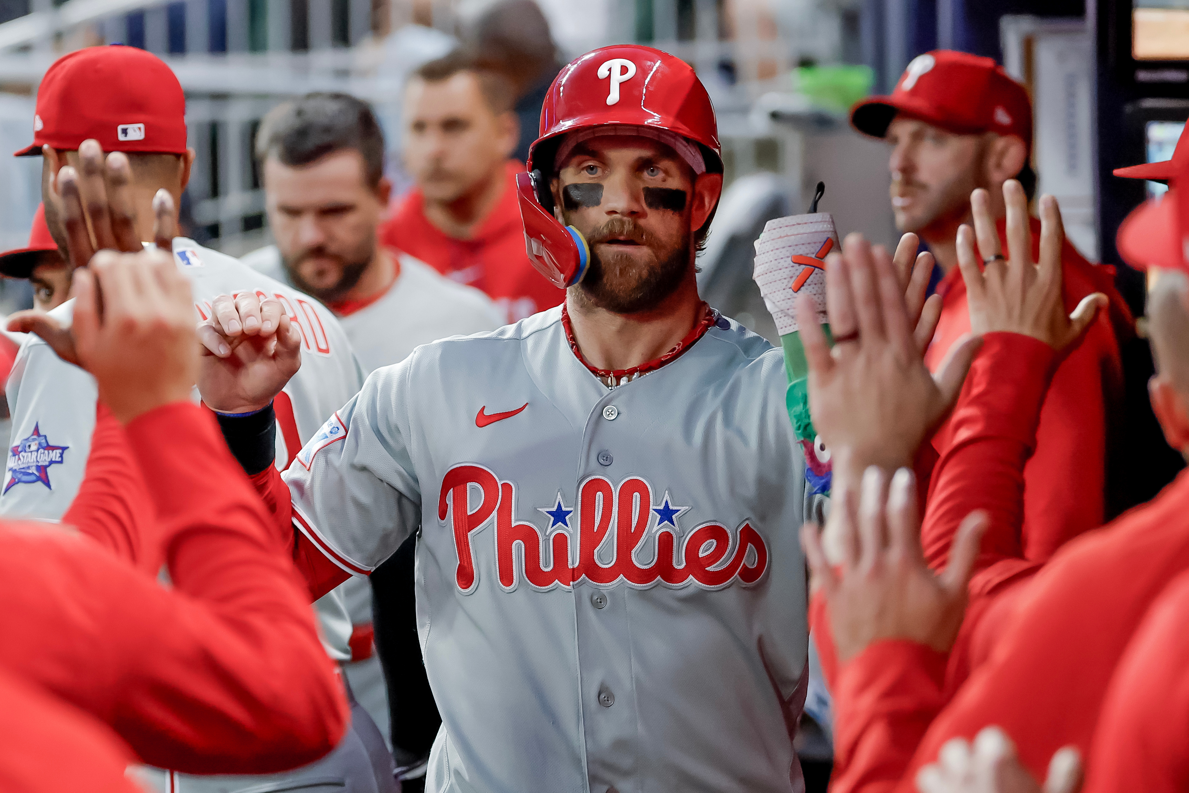 Philadelphia Phillies' Bryce Harper is greeted in the dugout after scoring against the Atlanta Braves during the first inning of a baseball game, Saturday, April 25, 2026, in Atlanta. 