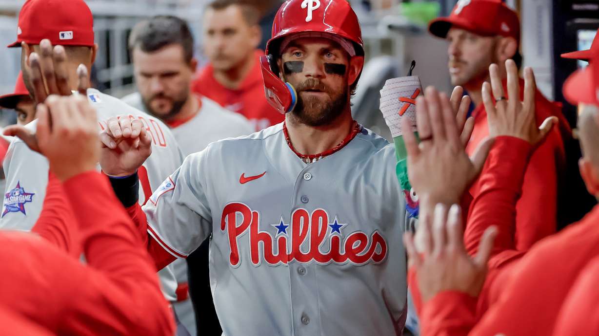 Philadelphia Phillies' Bryce Harper is greeted in the dugout after scoring against the Atlanta Braves during the first inning of a baseball game, Saturday, April 25, 2026, in Atlanta.