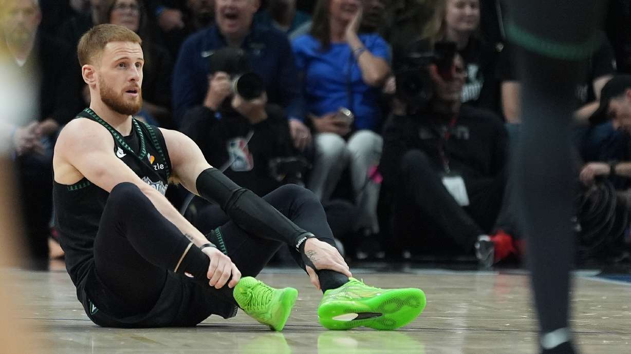 Minnesota Timberwolves guard Donte DiVincenzo (0) sits on the court after sustaining an injury during the first half of Game 4 of a first-round NBA basketball playoff series against the Denver Nuggets, Saturday, April 25, 2026, in Minneapolis.