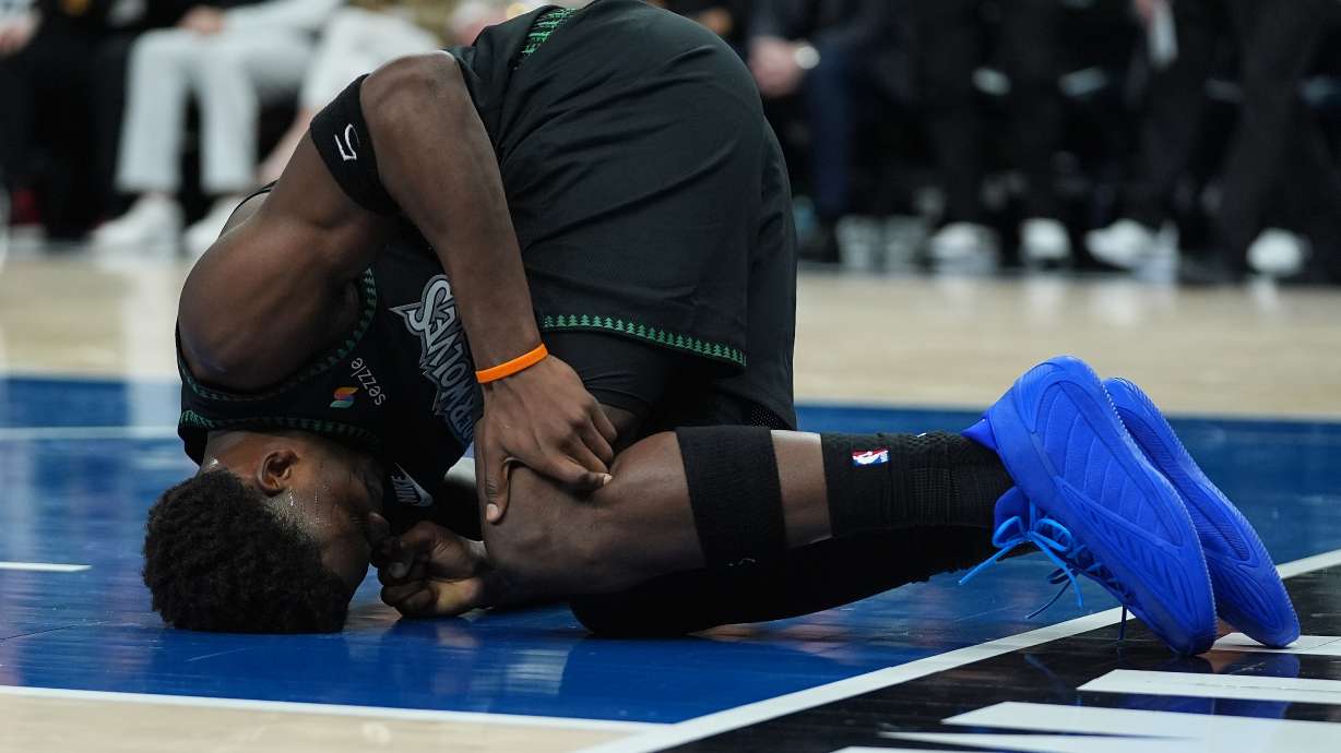Minnesota Timberwolves guard Anthony Edwards kneels on the court after sustaining an injury during the first half of Game 4 of a first-round NBA basketball playoff series against the Denver Nuggets, Saturday, April 25, 2026, in Minneapolis.