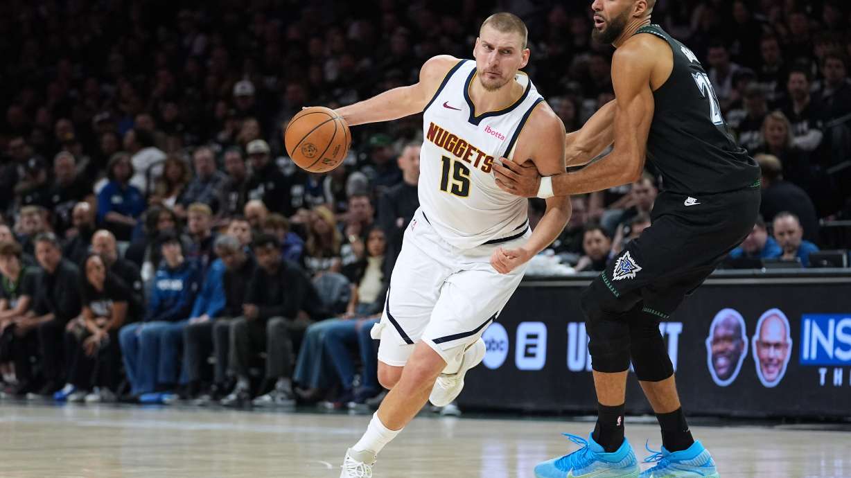 Denver Nuggets center Nikola Jokic (15) works toward the basket as Minnesota Timberwolves center Rudy Gobert, right, defends during the first half of Game 4 of a first-round NBA basketball playoff series, Saturday, April 25, 2026, in Minneapolis.