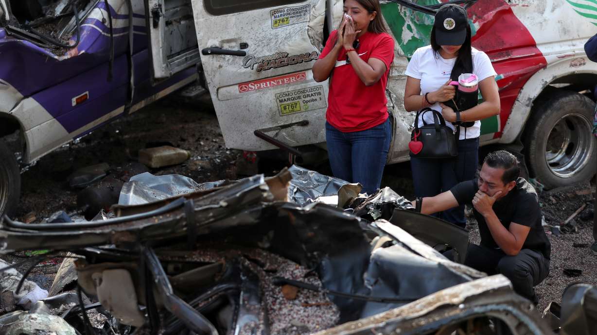 Relatives of victims pay respects at the site of an attack on the Pan-American Highway in Cajibio, Colombia, Sunday, where at least a dozen people were killed in an attack authorities blamed on dissident groups of the former FARC rebels.