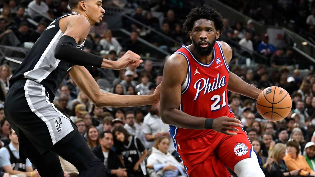 Philadelphia 76ers center Joel Embiid (21) drives against San Antonio Spurs center Victor Wembanyama, left, during the first half of an NBA basketball game, Monday, April 6, 2026, in San Antonio.