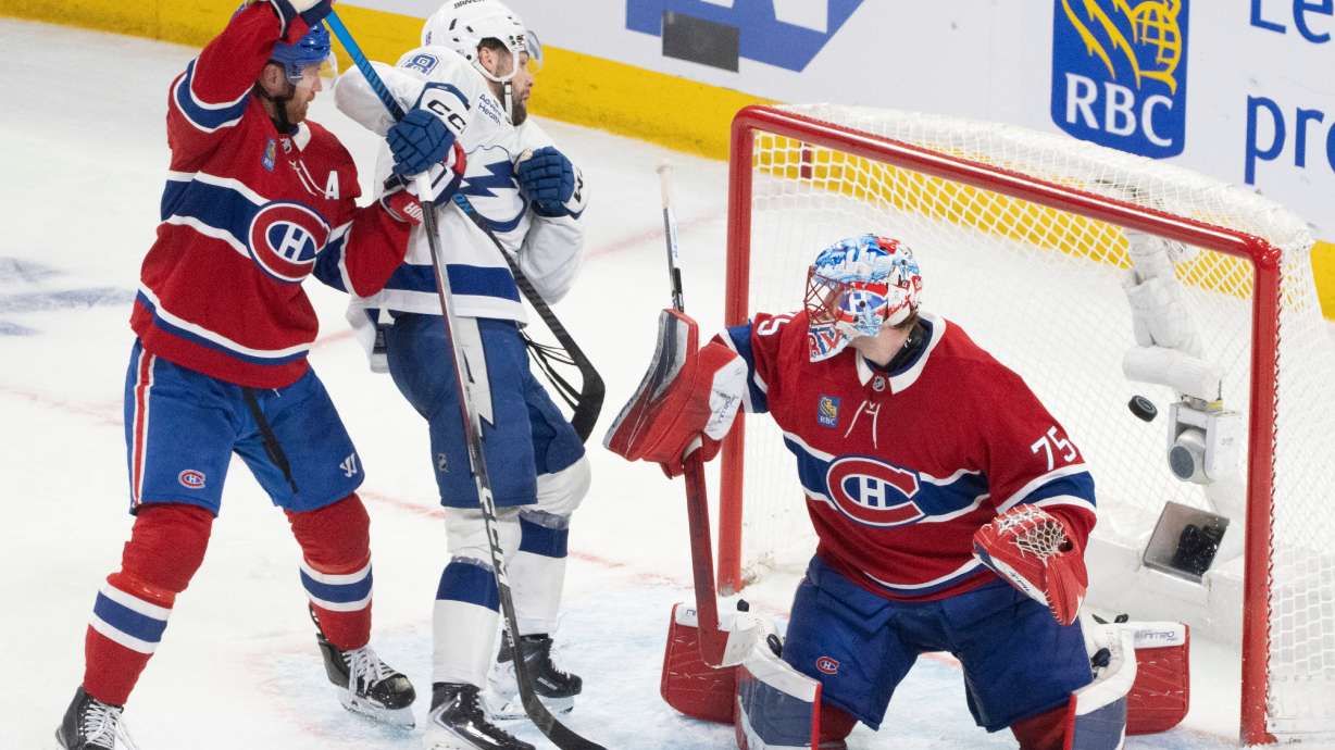 Tampa Bay Lightning's Brandon Hagel (38) scores past Montreal Canadiens goaltender Jakub Dobes (75) and Mike Matheson (8) during the third period of an NHL playoff hockey game, in Montreal, Sunday, April 26, 2026.