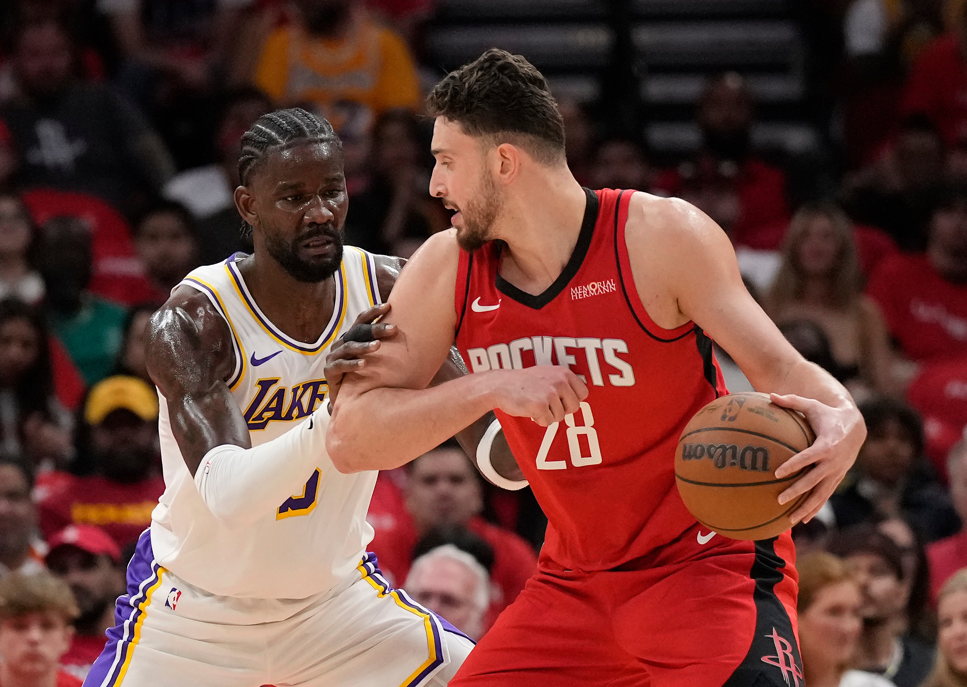 Houston Rockets center Alperen Sengun (28) controls the ball against Los Angeles Lakers center Deandre Ayton (5) during the first half in Game 4 of a first-round NBA basketball playoffs series, Sunday, April 26, 2026, in Houston. 
