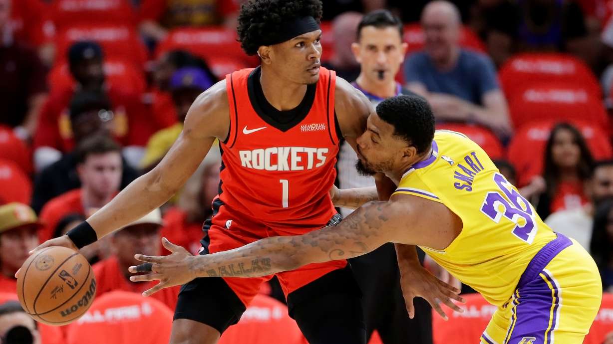Houston Rockets guard Amen Thompson (1) looks to drive around Los Angeles Lakers guard Marcus Smart (36) who reaches in during the first half of Game 3 in a first-round NBA playoffs basketball series Friday April 24, 2026, in Houston.