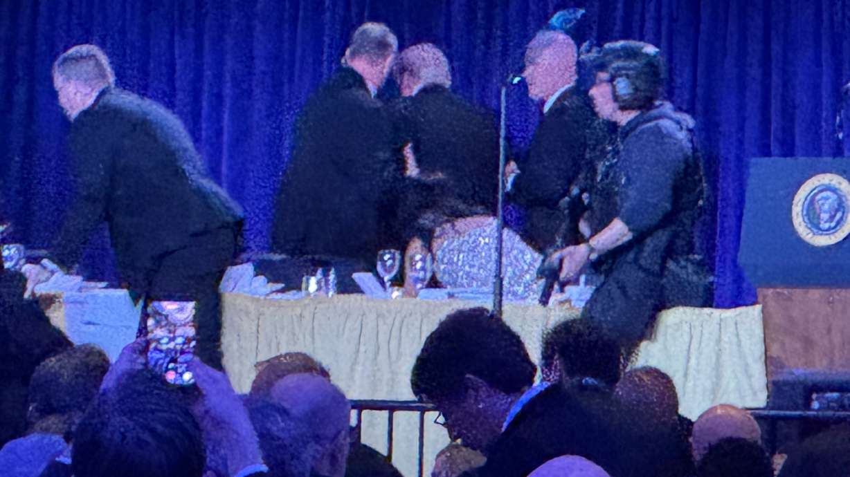 U.S. Secret Service agents surround President Donald Trump as he is taken from the stage after a shooting incident outside the ballroom at the White House Correspondents Dinner, Saturday in Washington.