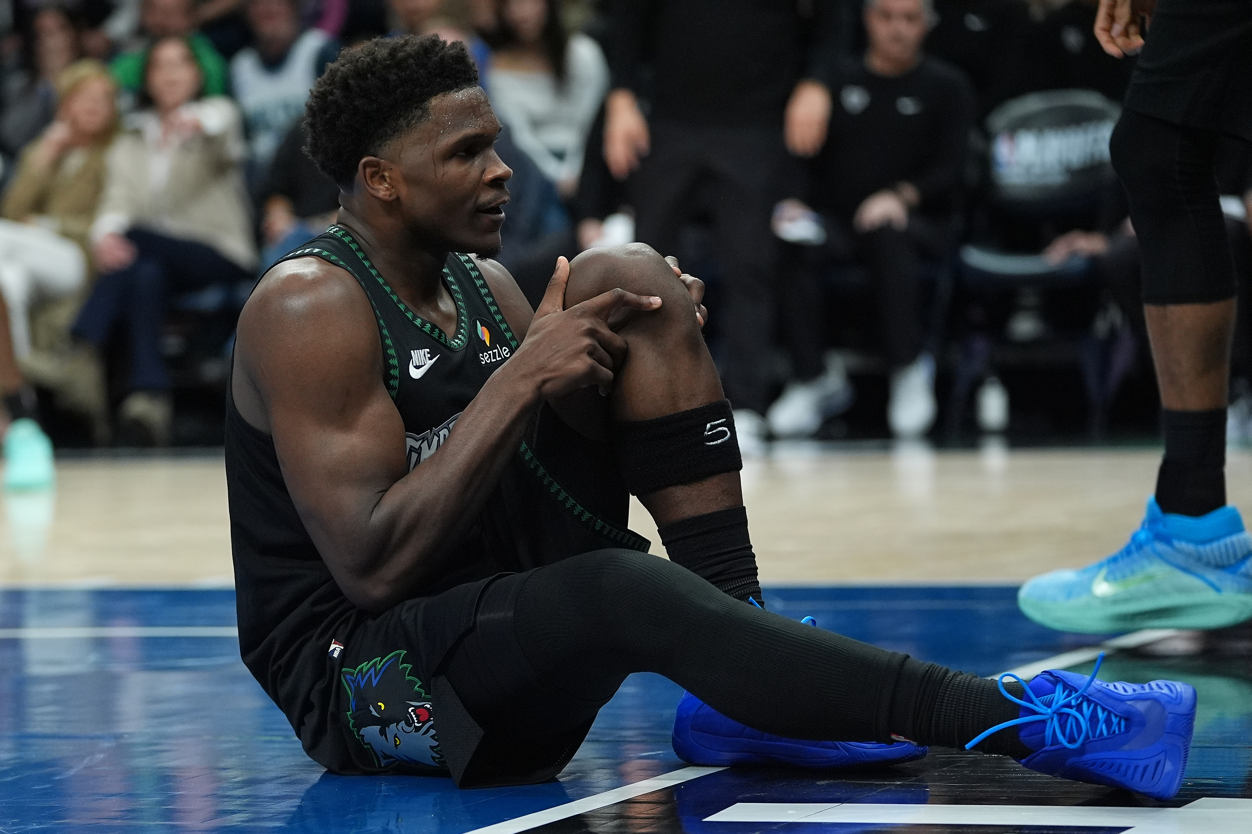 Minnesota Timberwolves guard Anthony Edwards grabs his knee after an injury during the first half of Game 4 of a first-round NBA basketball playoff series against the Denver Nuggets, Saturday, April 25, 2026, in Minneapolis.