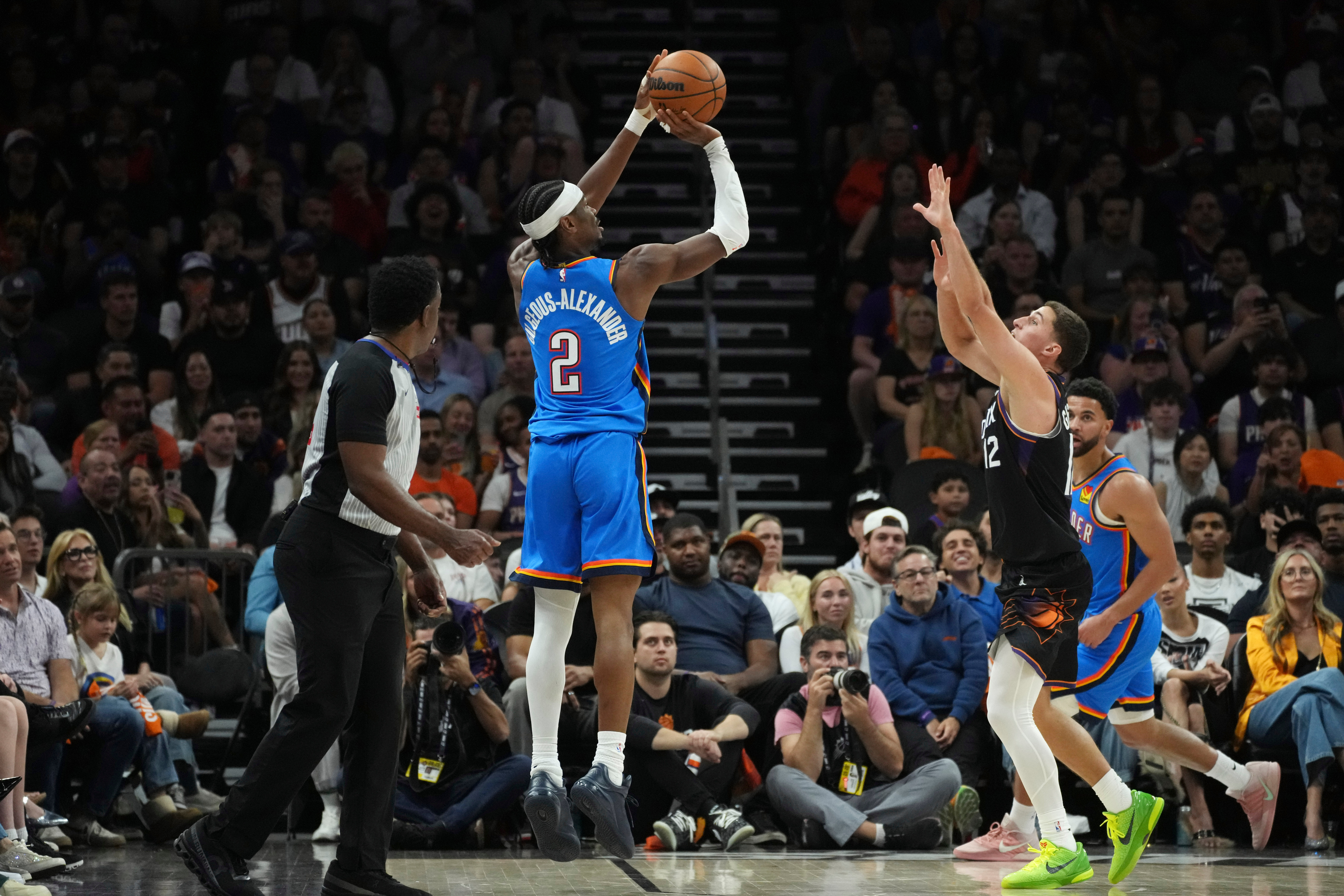 Oklahoma City Thunder guard Shai Gilgeous-Alexander (2) shoot a 3-pointer against Phoenix Suns guard Collin Gillespie (12) during the first half of Game 4 in a first-round NBA playoffs basketball series, Monday, April 27, 2026, in Phoenix. 