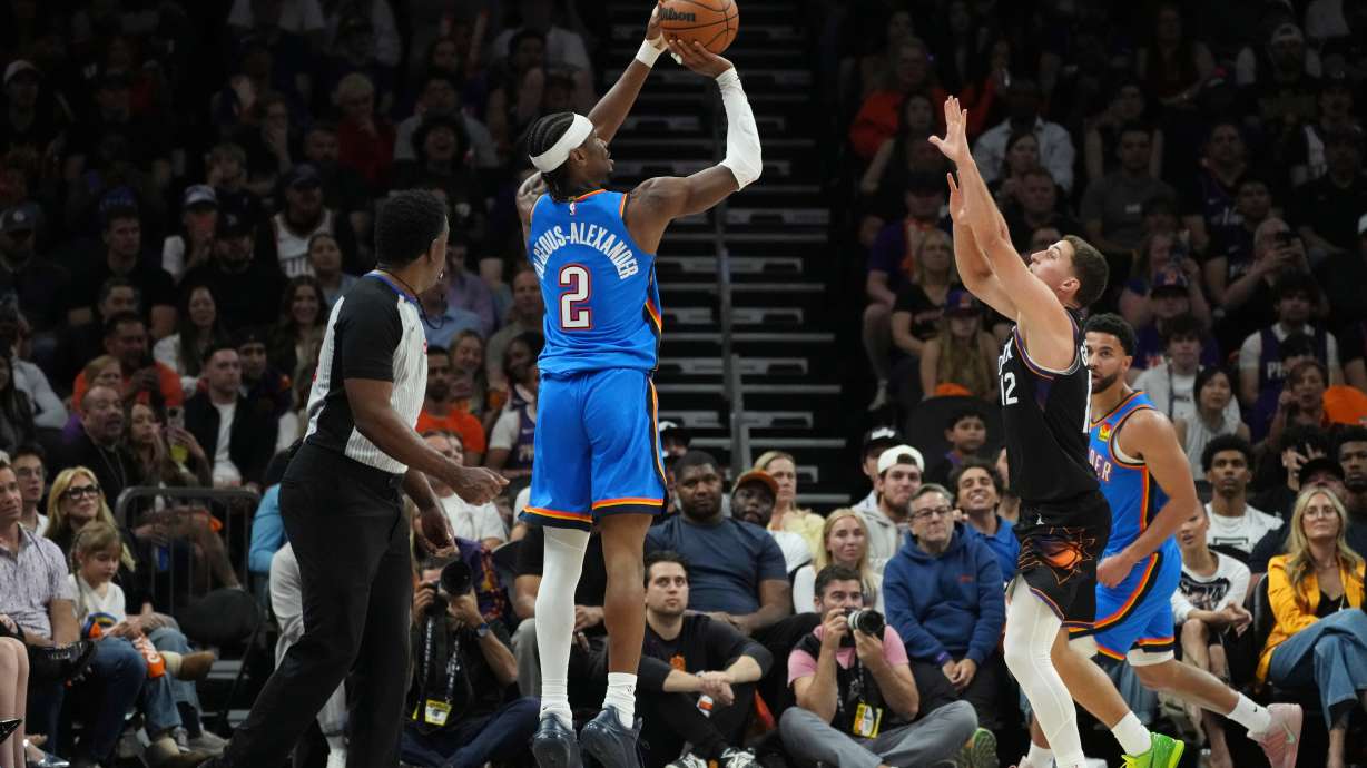 Oklahoma City Thunder guard Shai Gilgeous-Alexander (2) shoot a 3-pointer against Phoenix Suns guard Collin Gillespie (12) during the first half of Game 4 in a first-round NBA playoffs basketball series, Monday, April 27, 2026, in Phoenix.