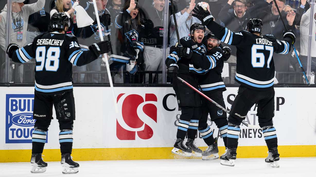 Utah Mammoth right wing Clayton Keller, center left, reacts to scoring a goal with teammates Utah Mammoth defenseman MacKenzie Weegar, center right, Utah Mammoth left wing Lawson Crouse, right, and Utah Mammoth defenseman Mikhail Sergachev, left, during the third period of Game 4 of a first-round NHL hockey Stanley Cup playoff series, Monday, April 27, 2026, in Salt Lake City.