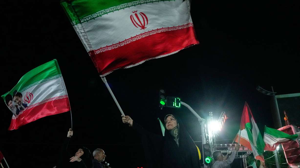 Pro-government demonstrators wave Iranian flags during a gathering in Tehran, Iran, April 27.