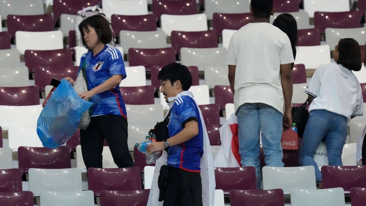 FILE - Japan supporters clean the stands at the end of the World Cup group E soccer match between Germany and Japan, at the Khalifa International Stadium in Doha, Qatar, Wednesday, Nov. 23, 2022.