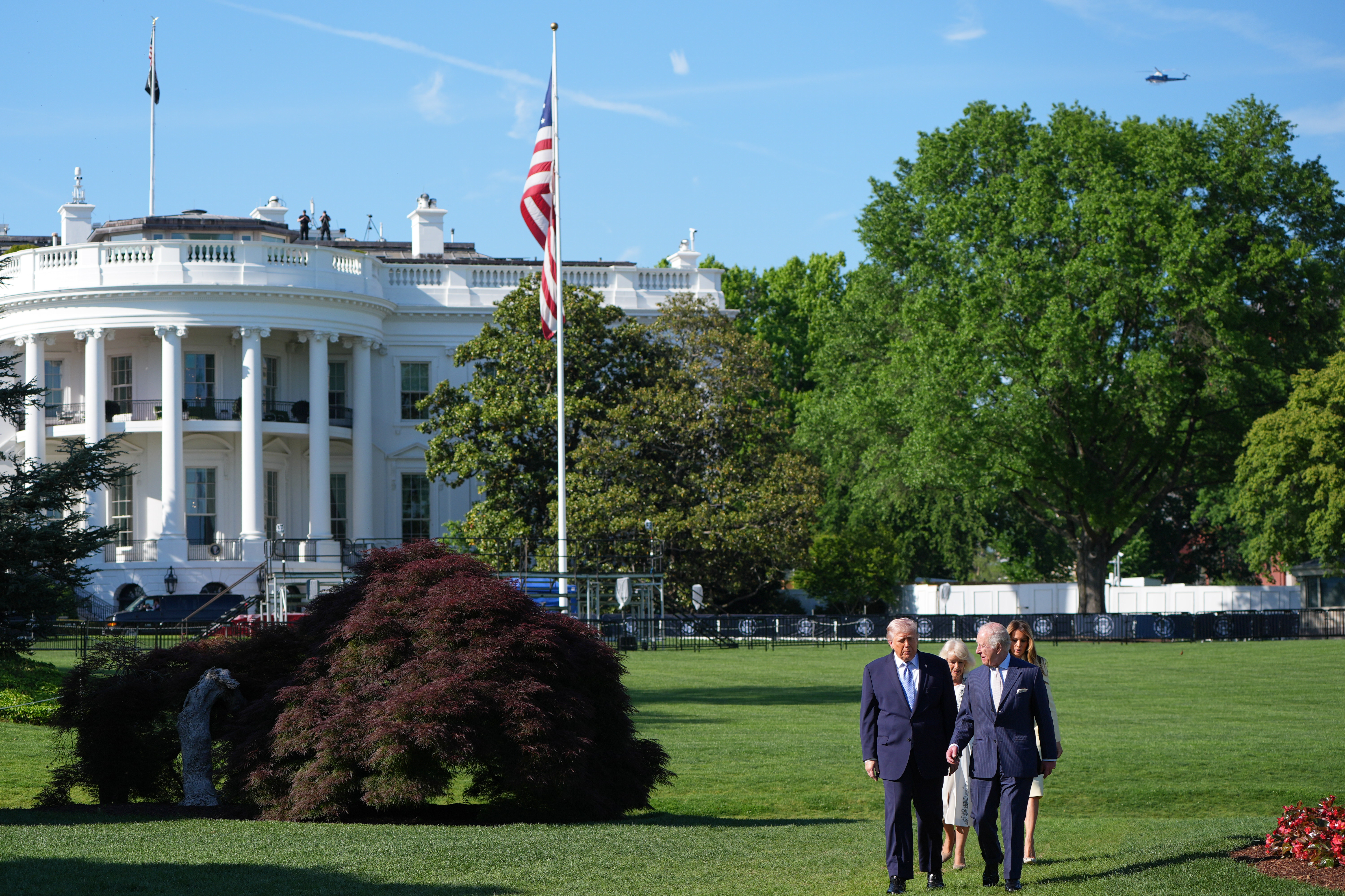 President Donald Trump and first lady Melania Trump along with Britain's King Charles III and Queen Camilla walk on the South Lawn to visit the White House garden and bee hive at the White House, Monday, in Washington.