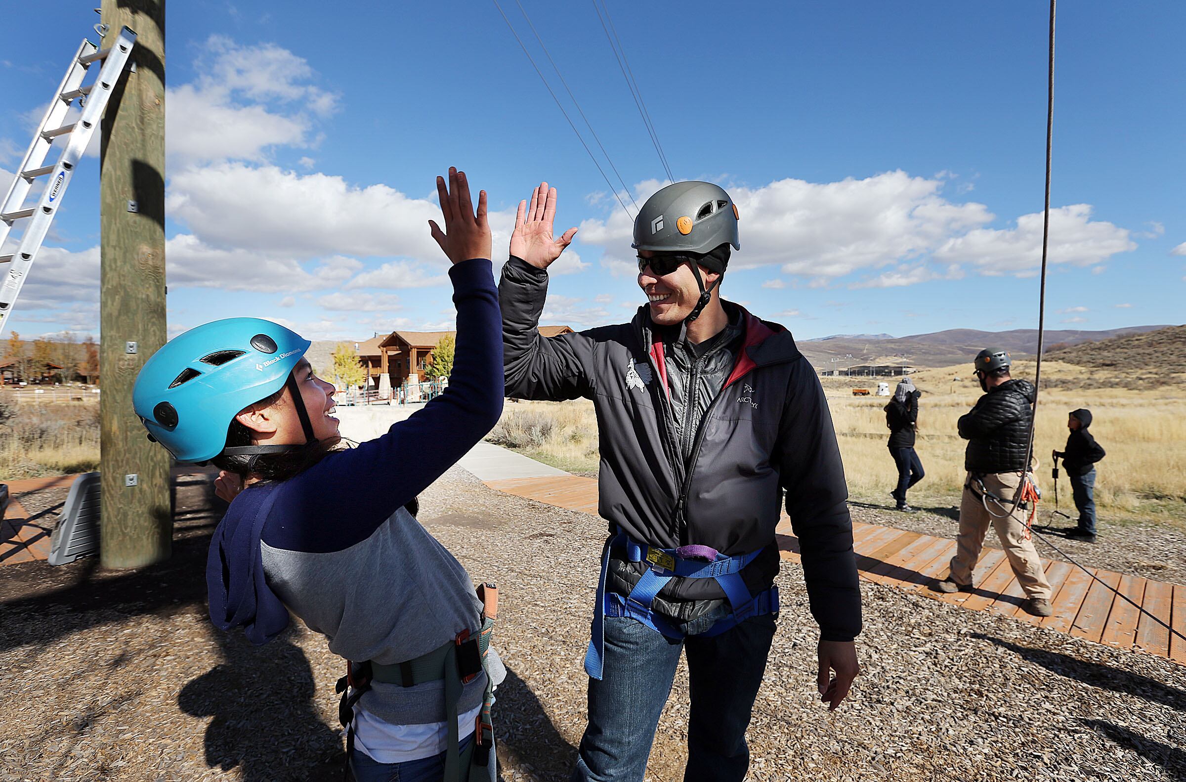 Luis Garcia high-fives his daughter Zinnia as they participate in a ropes course during the R and R program at the National Ability Center in Park City on Oct. 19, 2016.