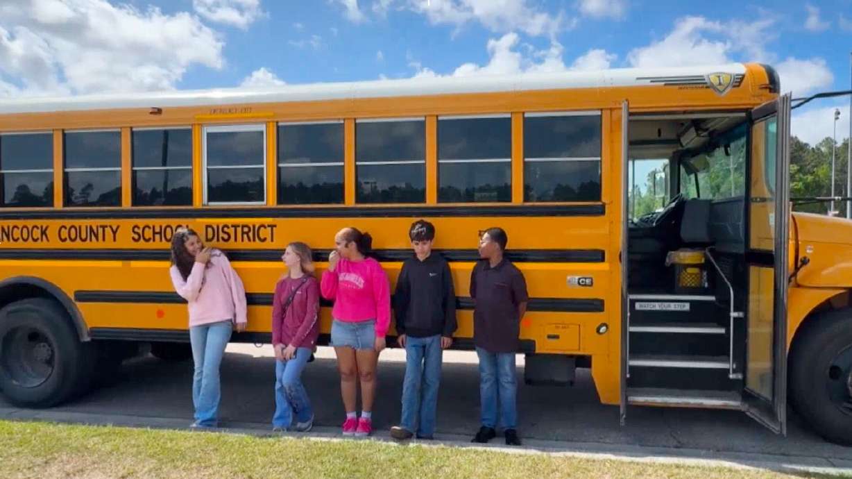 Five middle school students, who helped stop a bus after their driver passed out during a medical emergency, stand outside a bus in Hancock County, Miss., on Thursday. The students were honored at a pep rally on Friday and will be treated to lunch sometime later this week.
