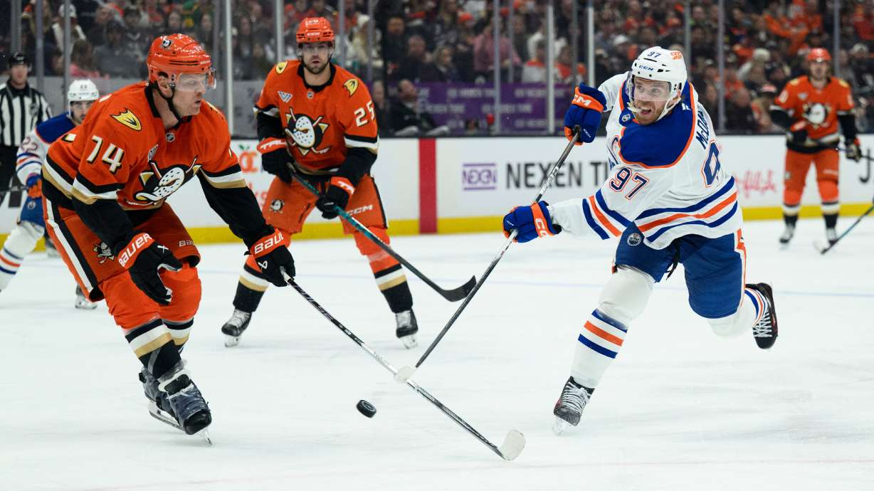 Edmonton Oilers center Connor McDavid, right, shoots as Anaheim Ducks defenseman John Carlson, left, defends during the second period of Game 4 in the first round of an NHL hockey Stanley Cup playoff series Sunday, April 26, 2026, in Anaheim, Calif.