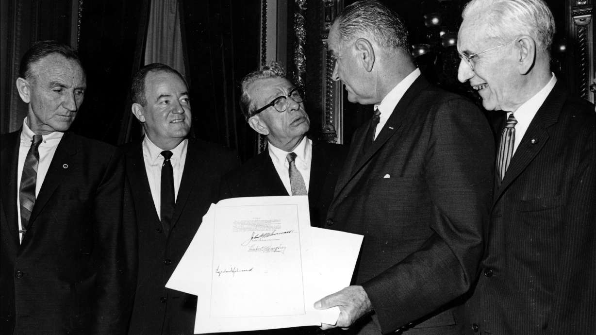President Lyndon B. Johnson holds the signed document of the Voting Rights Act of 1965 as he chats with Sen. Everett Dirksen, R-Ill., in the President's Room in Washington, Aug. 6, 1965. The Voting Rights Act over its six decades became one of the most consequential laws in the nation's history.