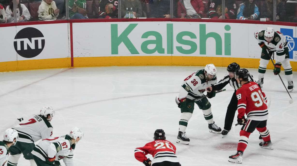 A face-off during the third period of an NHL hockey game between the Chicago Blackhawks and the Minnesota Wild with the Kalshi sign in the background Tuesday, March, 17, 2026, in Chicago.