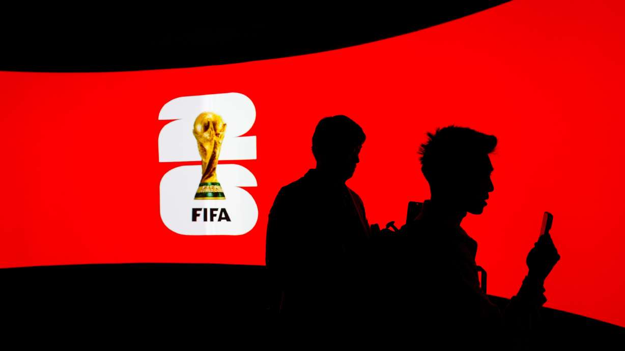People are silhouetted against a video screen during the launch of the FIFA World Cup trophy tour in Vancouver, on Friday, April 10, 2026.
