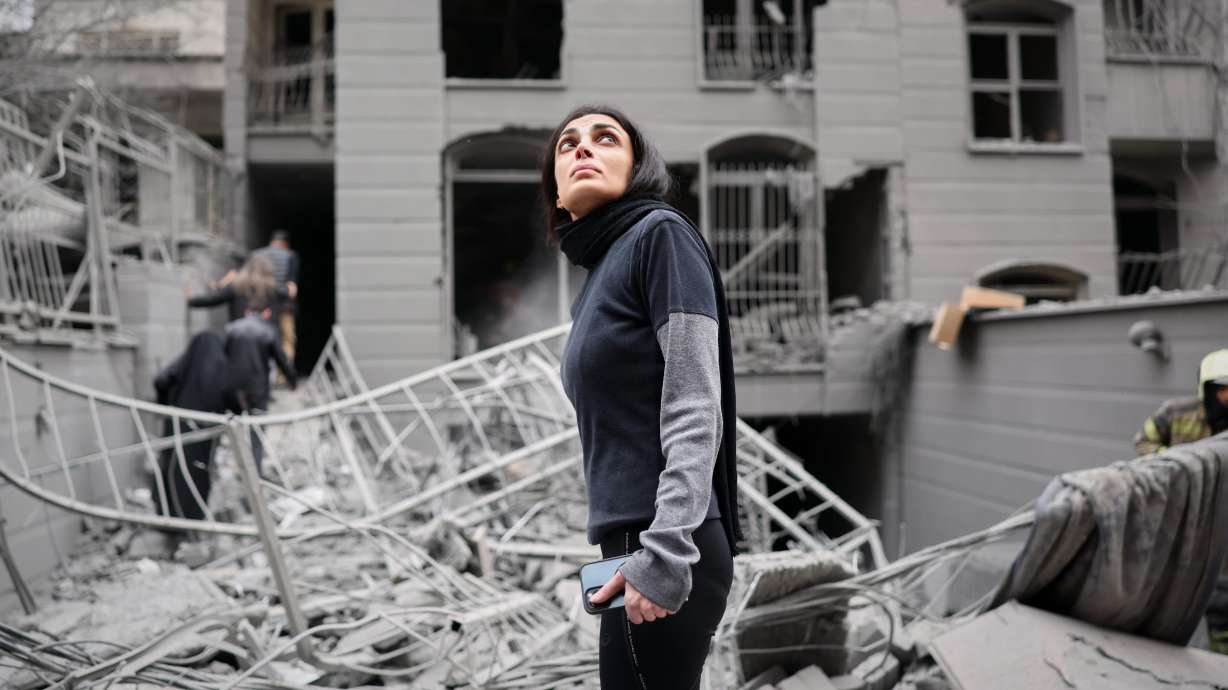 A woman looks up at the site of a strike that hit a residential building amid the U.S.-Israeli military campaign in Tehran, Iran, March 28.